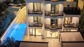 Un hotel de varios pisos con piscina, balcones y un cartel que dice 'HOTEL ZURICH'.