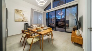 Een moderne eethoek met een houten tafel, stoelen en een moderne lamp.