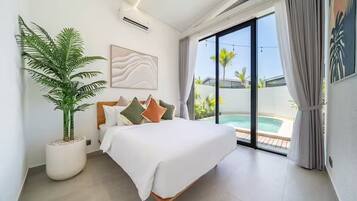 Un dormitorio moderno con cama, una planta grande en maceta, un cuadro y vistas a una piscina.