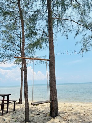 A beach with a swing set, a bench, and a view of the sea. - Hoa Tigon Hon Mot (Phu Quoc)