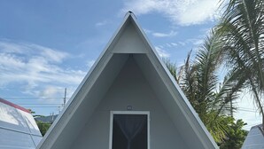 Uma estrutura triangular com uma porta e uma pequena mesa.