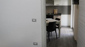 Ein kleines Zimmer mit Bett, einer Küchenzeile und einem Essbereich.