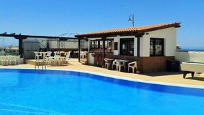 A poolside area with a bar and outdoor seating. - Beach Apartment in Amarilla Golf- Sleeps 4 (San Miguel de Abona)