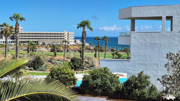A resort with a pool, palm trees, and a view of the ocean. - Beach Apartment in Amarilla Golf- Sleeps 4 (San Miguel de Abona)