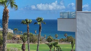 A view of a coastal area with palm trees and a clear sky. - Beach Apartment in Amarilla Golf- Sleeps 4 (San Miguel de Abona)