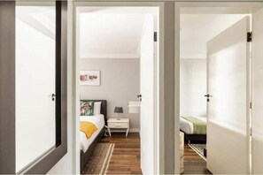 Ein Schlafzimmer mit Bett, Nachttisch, Lampe und einem Bild an der Wand.