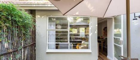 Una habitación pequeña con ventana, puerta y vistas al exterior.