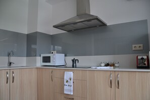 Eine moderne Küche mit Mikrowelle, Wasserkocher und Schränken.