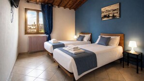 A hotel room with two beds, a window with a view of a cityscape, a radiator, and a painting on the wall. - Entire House Florence: 3 Bedrooms, 2 Bathrooms, and Free Parking by TuscanyWeGo (Firenze)