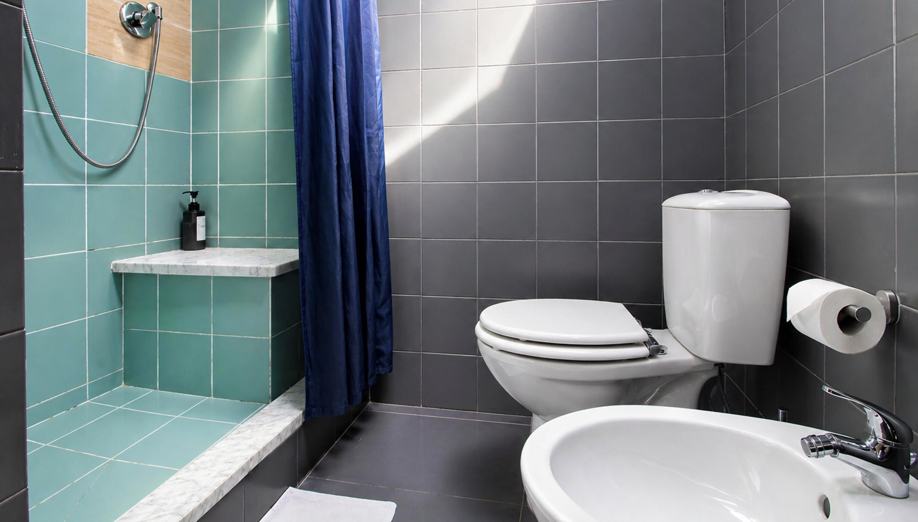 Ein Badezimmer mit Dusche, Toilette und Waschbecken.