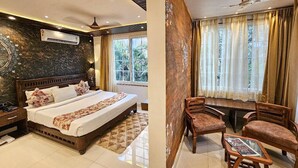 A bedroom with a bed, bedside table, and a window with curtains. - Serenity the villa by Beta Bawarchi (Pachmarhi)