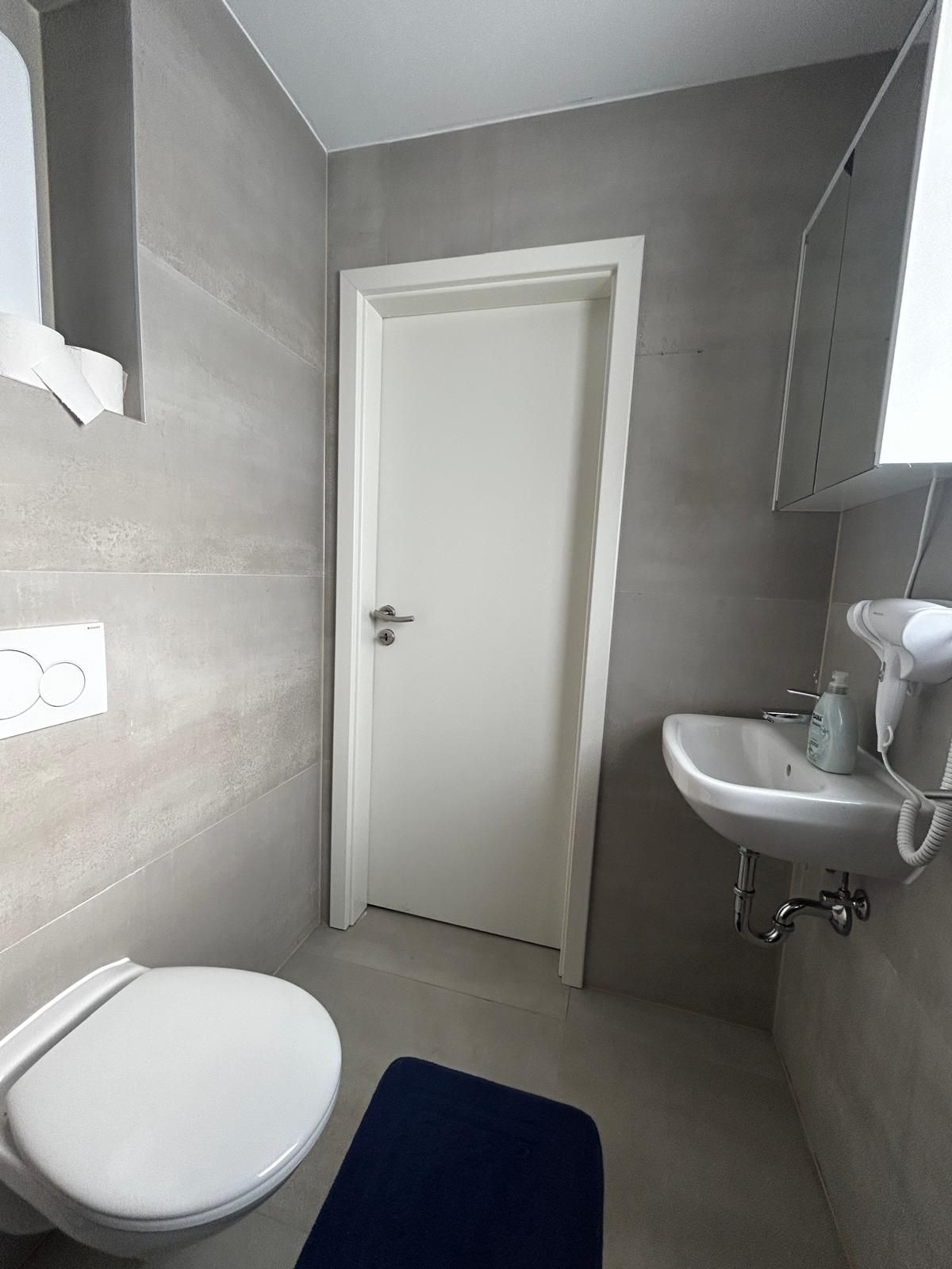 Ein Badezimmer mit Toilette, Waschbecken und Tür.