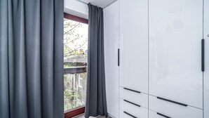 Una habitación moderna con un armario grande, una ventana con cortinas y vistas al exterior.