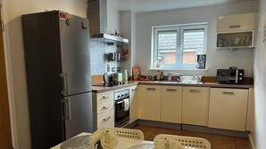Una cocina equipada con refrigerador, horno, lavaplatos y alacenas.