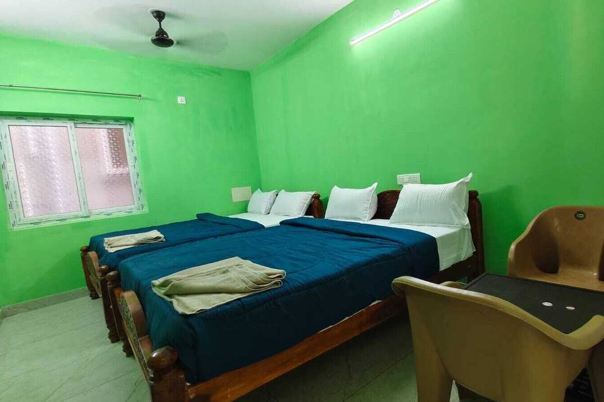 A room with two beds, a desk, and a chair.
