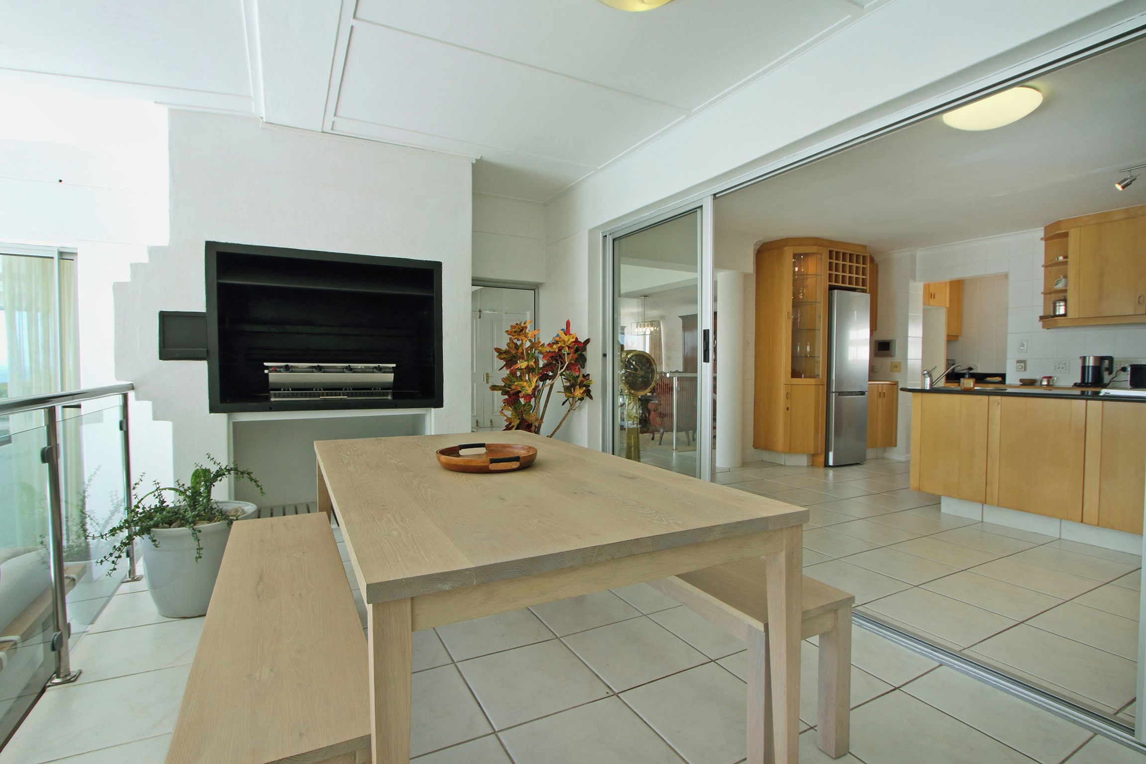 A modern kitchen with a central island, a built-in oven, and a refrigerator.