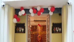 A doorway with a festive decoration, a chandelier, and a sign with 'Happy New Year' text. - Atithi Sevalay (Varanasi)