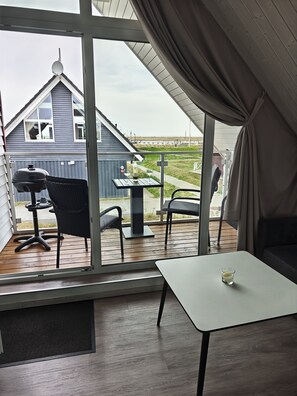 Ein Zimmer mit Blick auf ein Haus, einen Grill und einen Tisch mit Kerze.