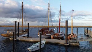 A marina with several boats docked at wooden piers. - "Strandgut" Marina Wendtorf holiday home by the beach with sea view (Wendtorf)