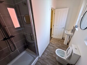 Regadera, toallas, papel de baño 
