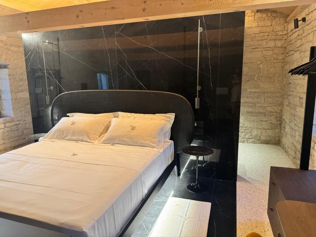 Un dormitorio con cama, una mesita y una lámpara colgante.