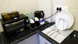 Un angolo cottura con tostapane, macchina per il caffè e scolapiatti.