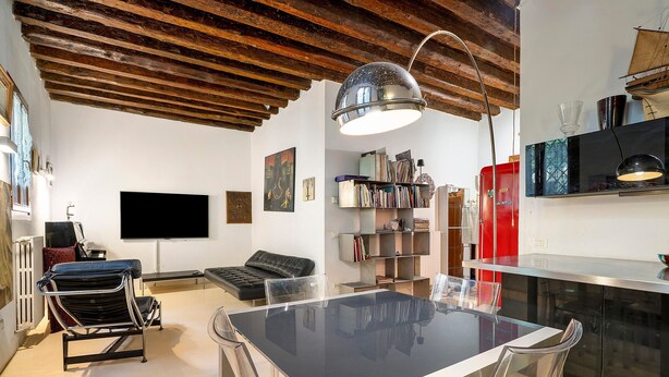 A modern living room with a dining table, a sofa, a TV, and a bookshelf. - Cà Leon, Artist’s Loft in the Heart of the City (Venezia)