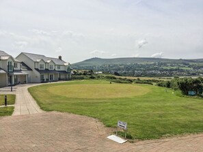 A residential area with houses, a paved pathway, and a sign indicating a fire safety point. - The Bolthole (Newport)