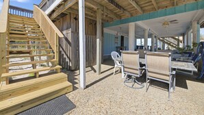 A covered outdoor area with a wooden staircase, seating, and a ceiling fan. - Family Fun Minutes from the Waters Edge (Pensacola Beach)