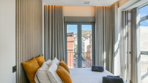 Une chambre d’hôtel moderne avec un grand lit, des rideaux et une vue sur les immeubles.