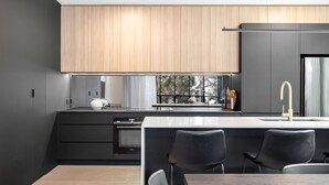 Una cocina moderna con una isla grande, armarios oscuros y una ventana con vistas.