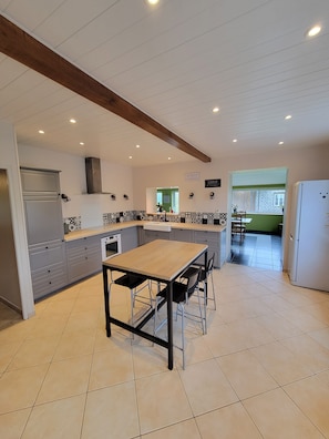 A modern kitchen with a central island, built-in appliances, and a dining area.