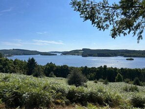 Ein See, umgeben von bewaldeten Hügeln.