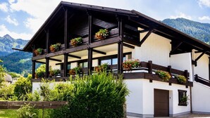 Ein traditionelles Chalet mit Balkon, Holzbalken und Blumenkästen.