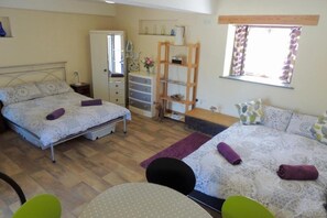 A bedroom with two beds, a wardrobe, a desk, and a window with curtains. - Rest, Reconnect & Gather at a Historic Cornish Barn (Saint Clether)