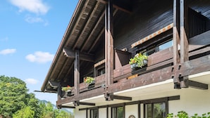 A wooden building with balconies, large windows, and a clear sky.