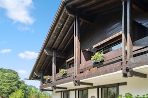 A wooden building with balconies, large windows, and a clear sky. - Double Room with Breakfast, Balcony and Mountain View (Vandans)