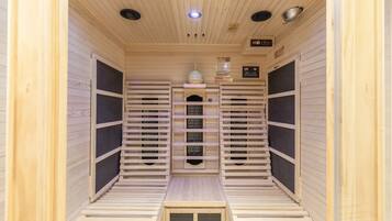 Eine Sauna mit Holzwänden und -bänken, einer Steuerung und einem Lüftungssystem.