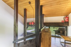 A wooden interior with a fireplace, a dining table, and a sofa. - Double Room with Breakfast, Balcony and Mountain View (Vandans)
