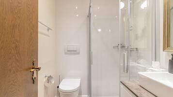 Ein modernes Badezimmer mit Duschkabine aus Glas, Toilette und Badewanne.