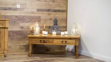 A wooden table with candles and a Buddha statue.