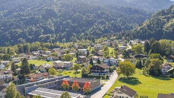 A residential area with houses, a road, and a building with solar panels.