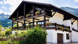 A traditional chalet with a balcony, wooden beams, and flower boxes. - Classic Double Room with Kitchenette, Terrace, and Mountain View (Vandans)