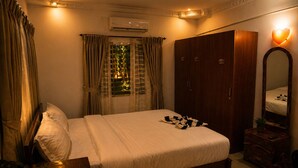 A hotel room with a bed, a wardrobe, a mirror, and an air conditioning unit. - Tremendous 3-bedroom villa in pleasant Hosur getaway (Denkanikottai)