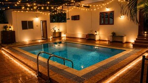 A rectangular indoor pool with a metal ladder, surrounded by wooden flooring and walls. - Tremendous 3-bedroom villa in pleasant Hosur getaway (Denkanikottai)