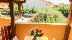 A balcony with a table, chairs, and a vase of flowers. - Magic DaLu House - Olbia (Olbia)