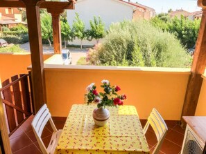 A balcony with a table, chairs, and a vase of flowers. - Magic DaLu House - Olbia (Olbia)
