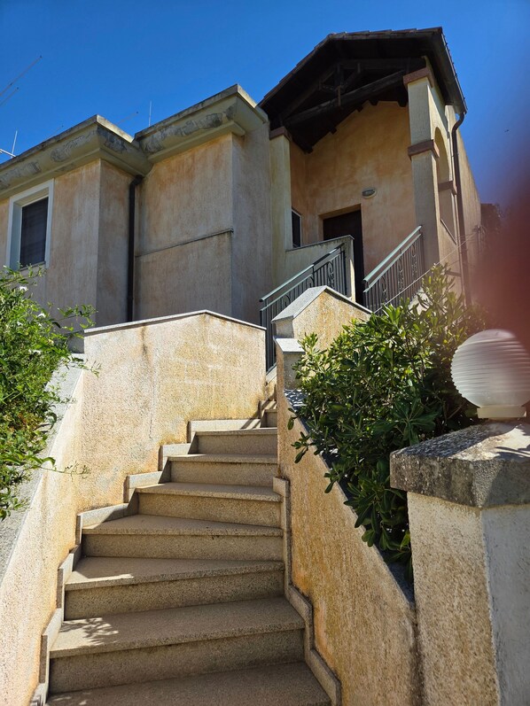 A set of stone steps leading to a building with a balcony and a window. - Charming Apartment in La Maddalena With Private Terrace (Capoterra)
