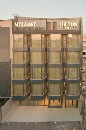 A hotel with a modern facade, featuring the name 'MELANGE HILTON WORKS' prominently displayed. - Melange Hotel (Gurugram)