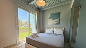 A bedroom with a bed, a window, a painting, and a towel. - Fouka North Coast SA-2B-B02 (Marsa Matrouh)